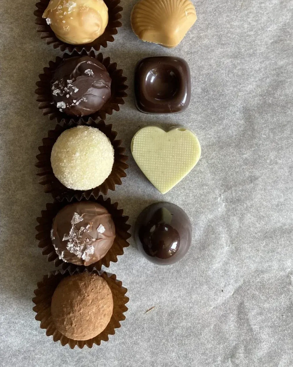 Närbild på Minas praliner – kolatryffel, snäcka i ljus choklad, flingsaltad tryffel och ett gjutet hjärta i vit choklad